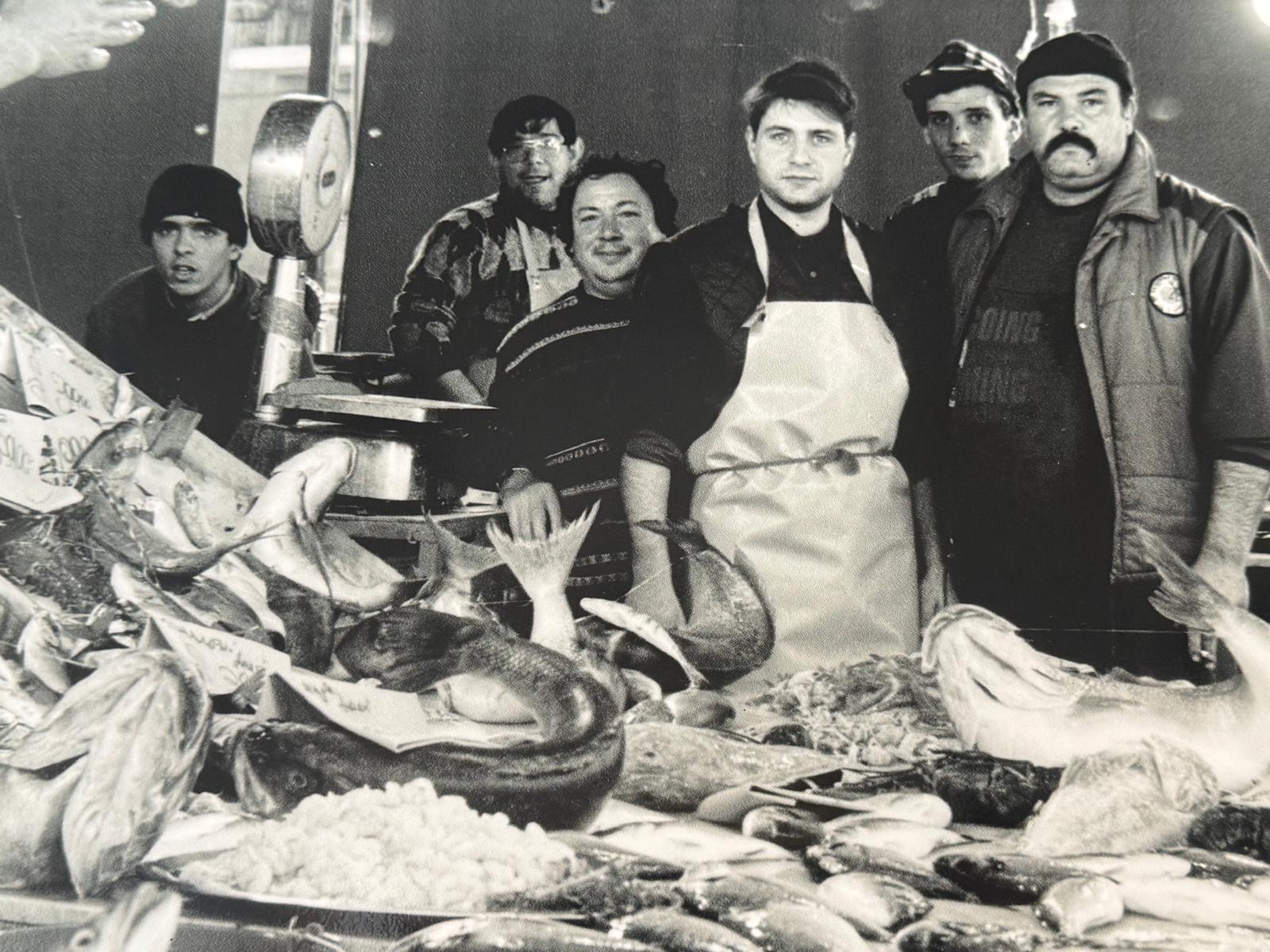 Foto storica in bianco e nero della famiglia al banco del pesce